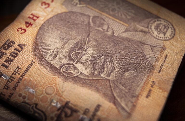 Indian currency notes placed next to a declining forex chart, representing the rupee opening lower amid U.S. tariff concerns in July 2025.